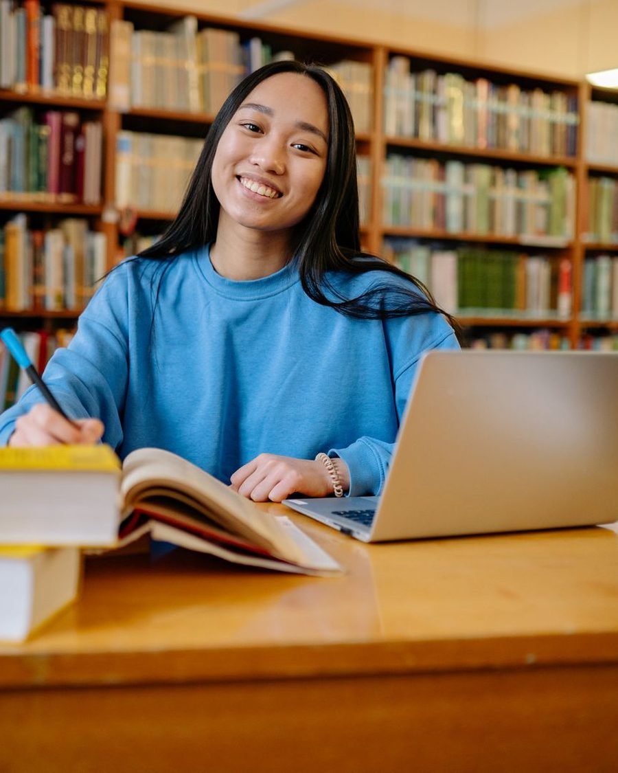 Student preparing for her PTE and TOEFL exams with a laptop and notes